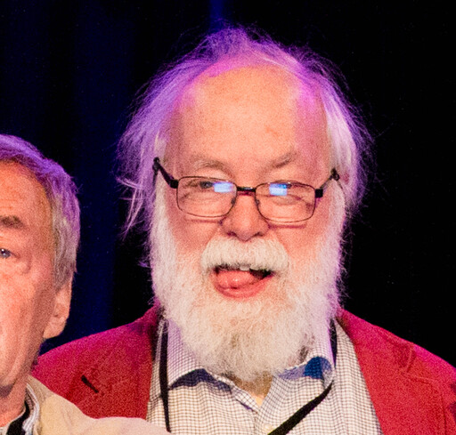 A silly picture of David Singmaster sticking out his tongue, standing next to Ernő Rubik.